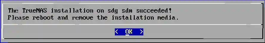 Success message for TrueNAS installation on drives sdg and sdm, prompting to reboot and remove the installation media.